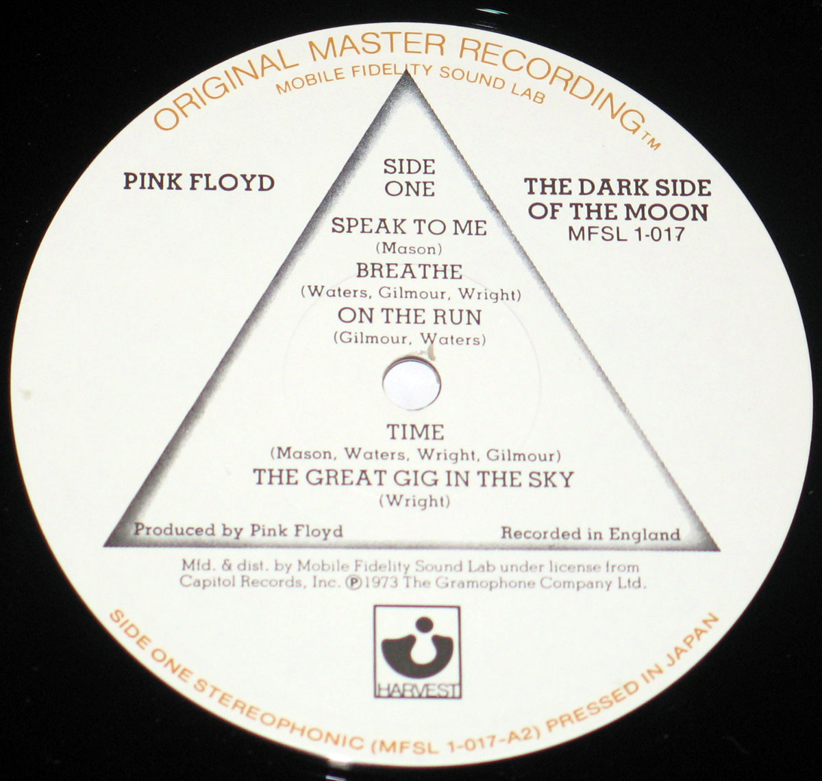 ‘Record label of Pink Floyd’s The Dark Side of the Moon Mobile Fidelity Sound Lab (MFSL) edition, catalog number MFSL 1-017. White label with a triangular prism design. Text at the top reads “Original Master Recording” and “Mobile Fidelity Sound Lab” in gold. Includes “Pink Floyd” and album title with catalog number. Bottom edge notes “Side One Stereophonic (MFSL 1-017-A2) Pressed in Japan” with Harvest Records logo.’